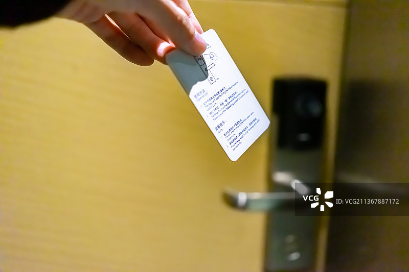 中国宾馆内部的房门，一只手拿着房卡正在刷卡开门图片素材