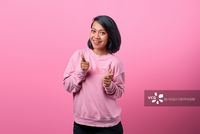 指向镜头的快乐年轻亚洲女子肖像照图片素材