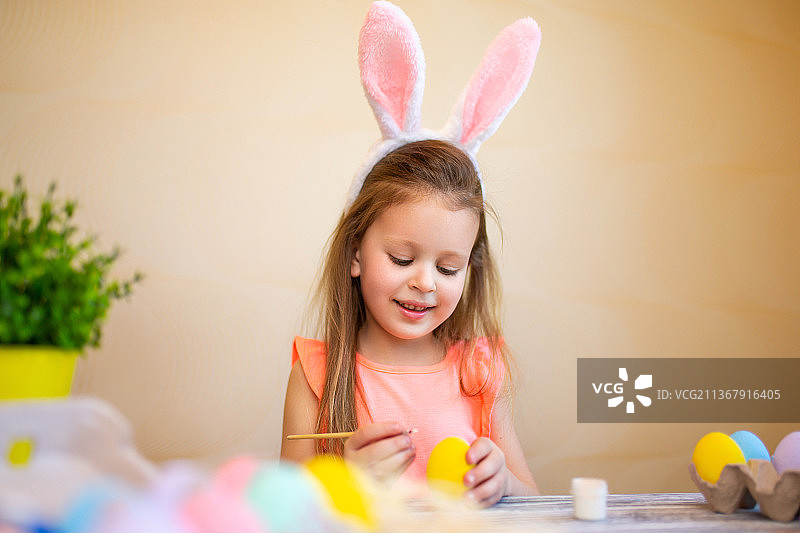 戴着兔子耳朵，准备画复活节彩蛋的可爱儿童图片素材