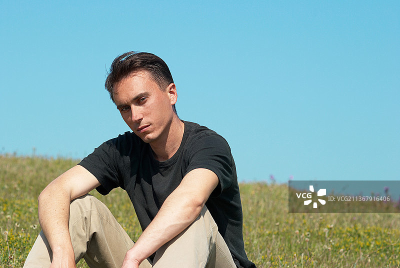 坐在草地上的年轻男人图片素材