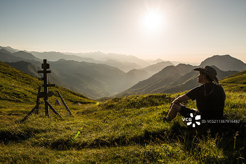 法国日落时分坐在山上的男子图片素材
