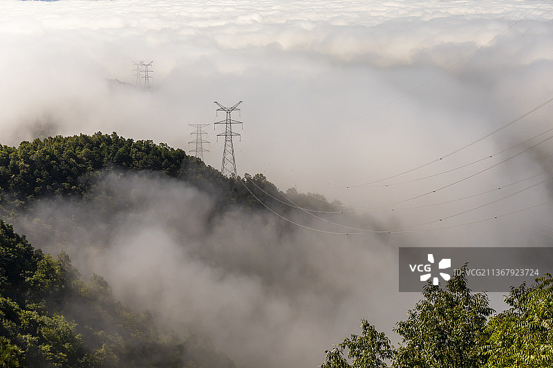 中国河南西部崤山山脉云海上高压输电线路图片素材