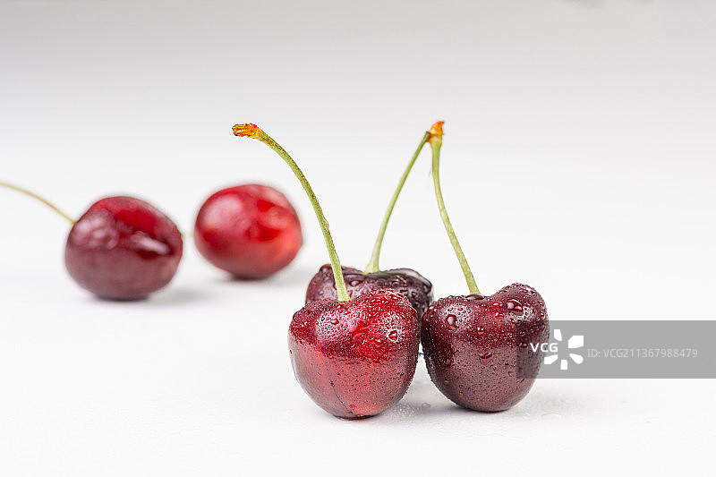 白色背景上带着露水的樱桃智利进口车厘子图片素材