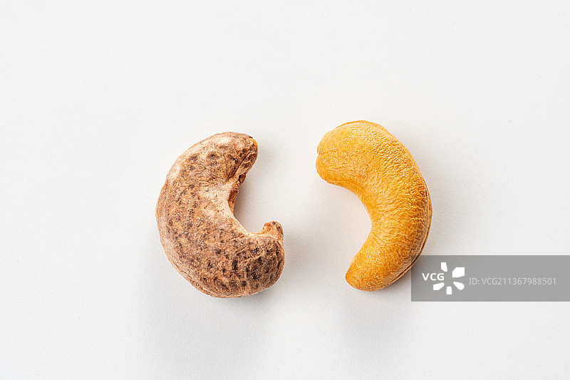 白色背景正扣视角拍摄的带衣腰果和果仁图片素材