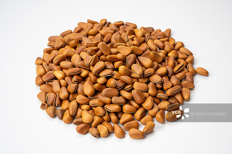 倾斜视角拍摄白色背景上的松子图片素材