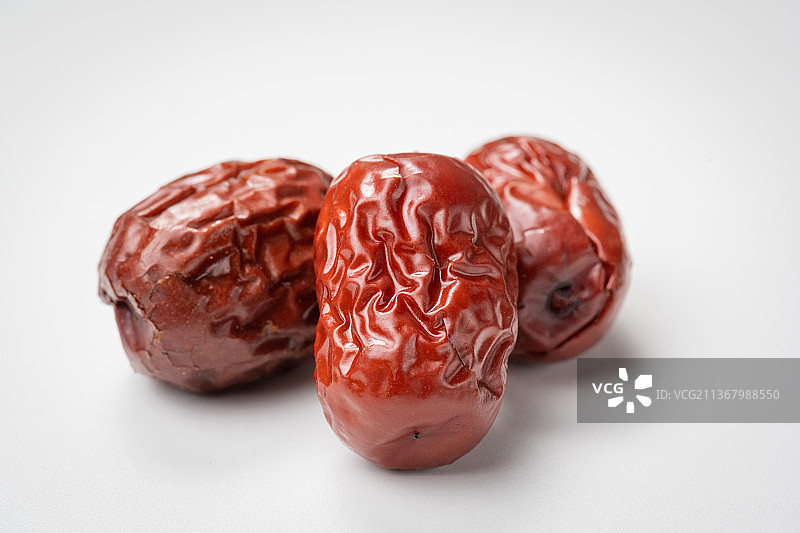 倾斜视角拍摄白色背景上的新疆红枣图片素材
