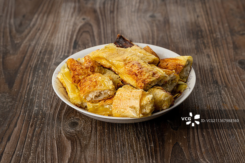 倾斜视角拍摄老桌木板上的豆皮卷图片素材