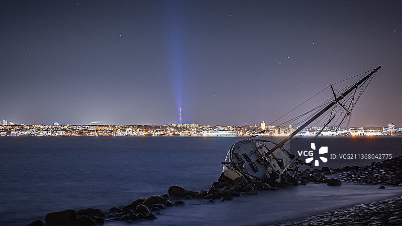 城市附近的沉船残骸，夜间海景图片素材