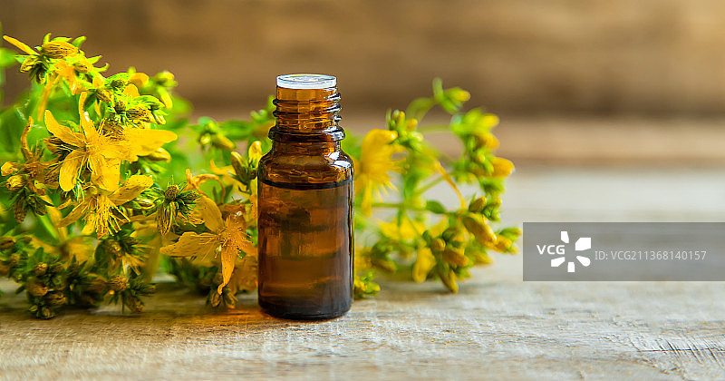 小瓶中的圣约翰草精油，选择性聚焦图片素材