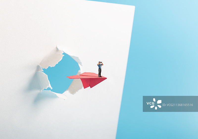 微缩创意站在纸飞机上拿着望远镜看远方的男性图片素材
