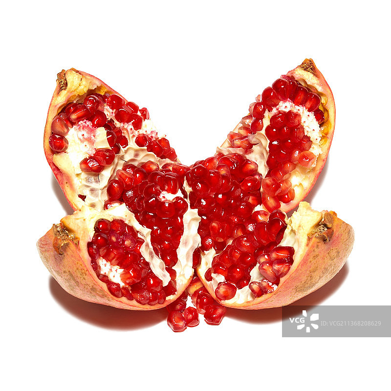 白色背景上分离的红色石榴和石榴籽图片素材