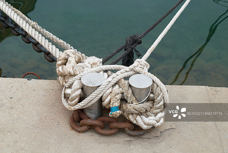 系泊和带绳子的系缆柱，高角度观察系在港口船上的绳子图片素材