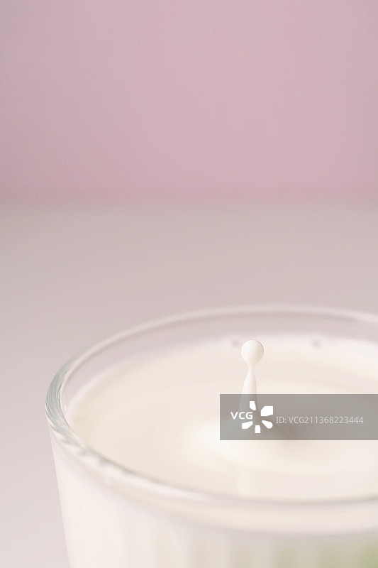 牛奶滴入透明玻璃杯图片素材