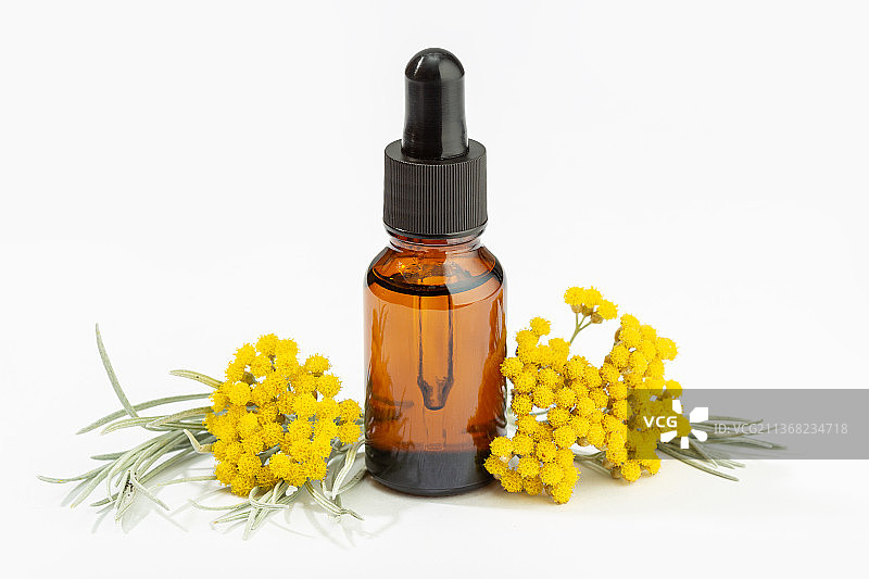 琥珀色瓶子里的蜡菊精油，白色背景图片素材