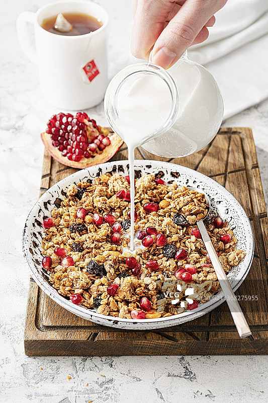 石榴什锦早餐与倾倒的牛奶图片素材