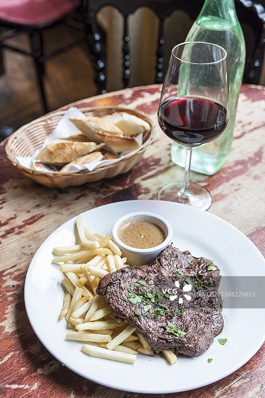 传统法式牛排薯条与肉汁和一杯红酒图片素材