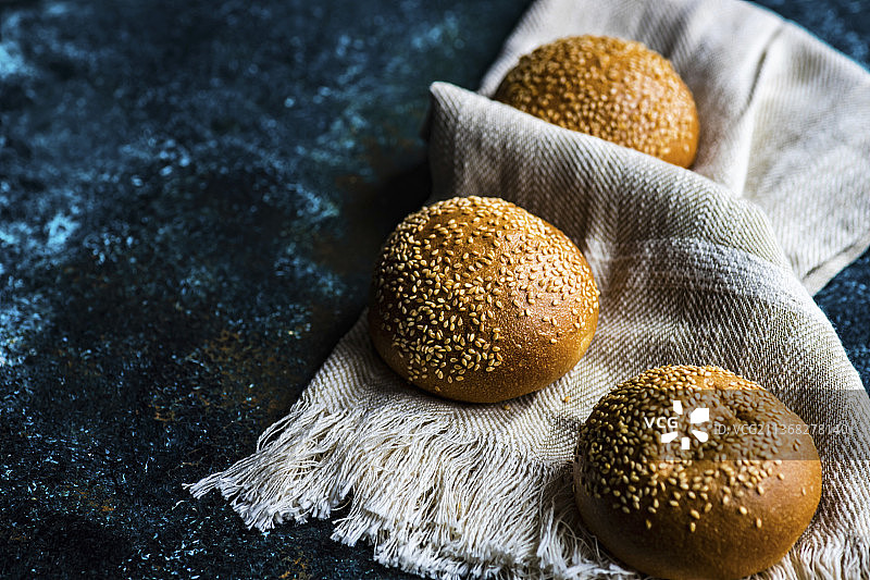 新鲜自制面包与棉质毛巾，水泥台背景图片素材