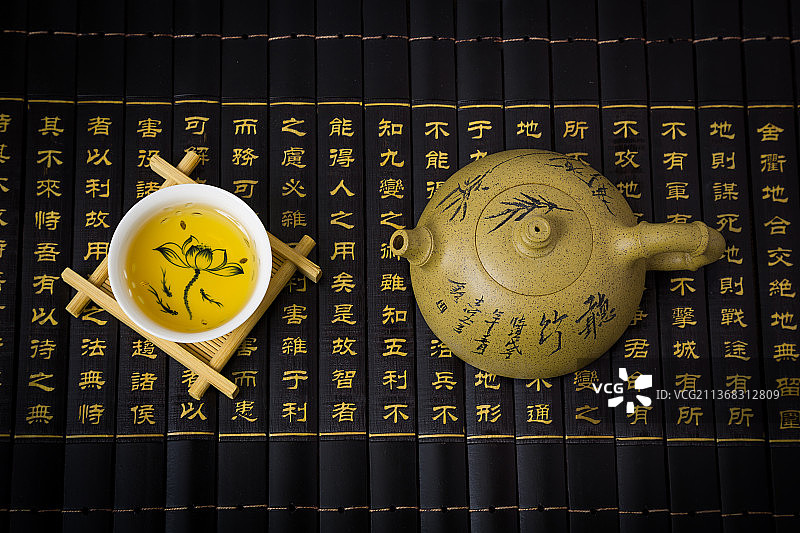 竹简上的段泥紫砂壶与茶杯图片素材