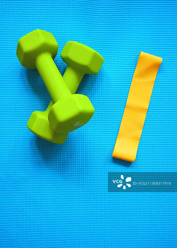 家庭健身房：蓝色背景上的哑铃高角度视图图片素材