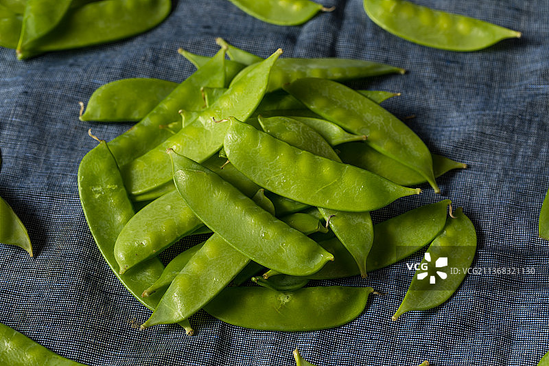 生的绿色有机雪豌豆，桌子上绿豌豆的特写镜头图片素材