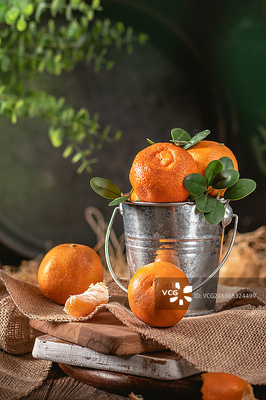 小装饰桶里的橘子，桌子上容器里的橙色水果特写，拉脱维亚图片素材