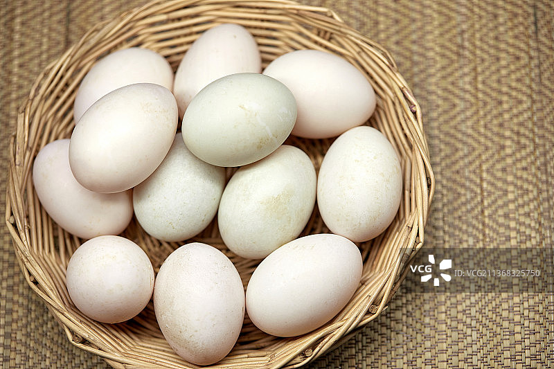 特写镜头：白色有机鸡蛋，泰国曼谷桌上的柳条筐特写图片素材