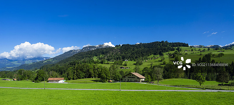 瑞士蓝天白云阳光下的草原山川村庄小镇风光图片素材