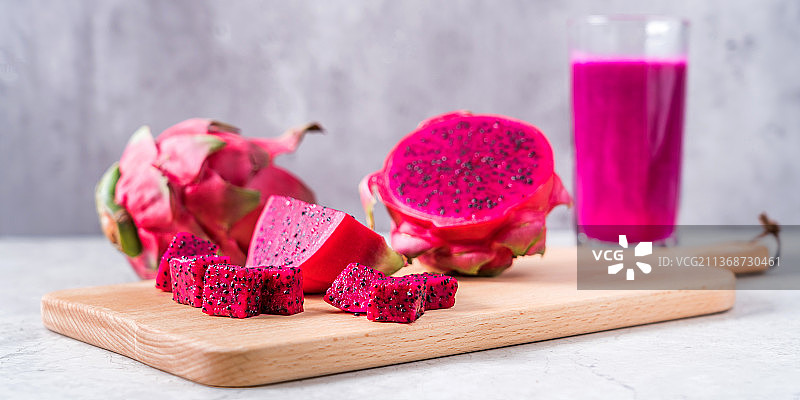 切开的红心火龙果和一杯火龙果汁图片素材
