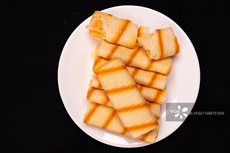 黑色背景的小吃食品蛋卷酥图片素材