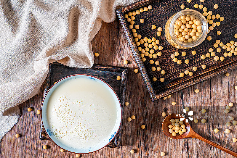 洒在桌面上的许多大豆和一碗豆浆图片素材