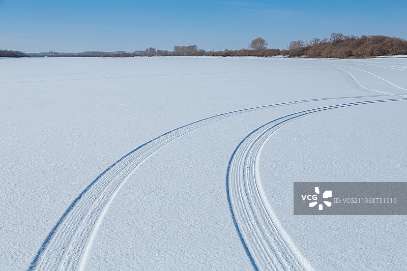 平整雪地上的汽车轮胎印，雪地车辙图片素材