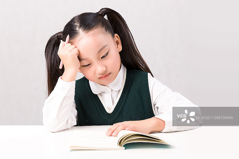 写作业的小学生低头思考图片素材