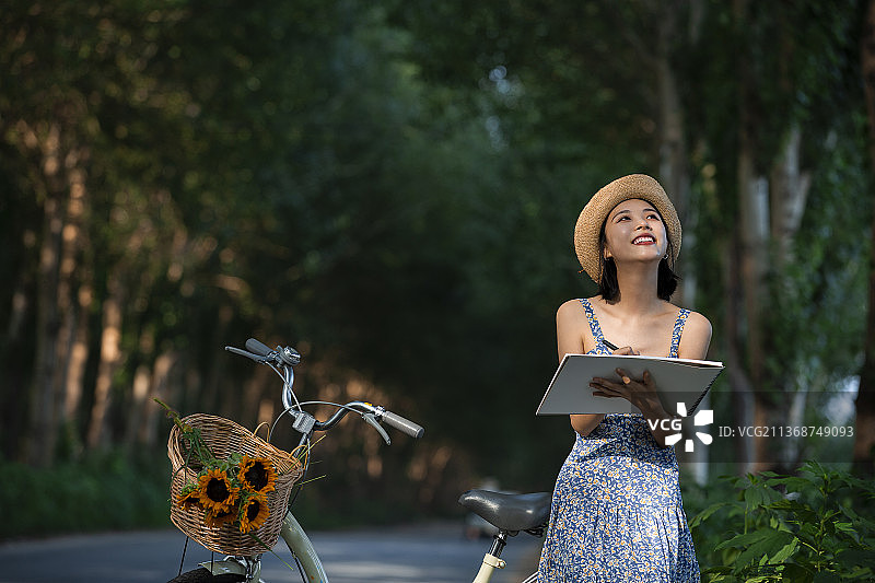 快乐女孩坐在自行车后座作画图片素材