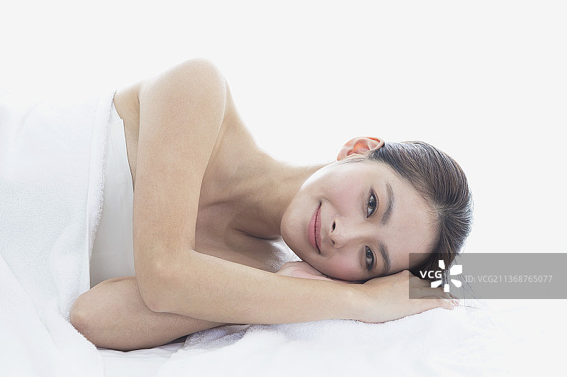 侧躺在美容床上的东方美女图片素材