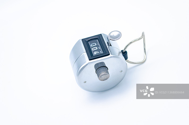 中国室内影棚拍摄静物办公文具，手按一个不锈钢计数器图片素材