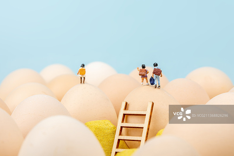 微缩景观小学生背着书包站在鸡蛋上图片素材