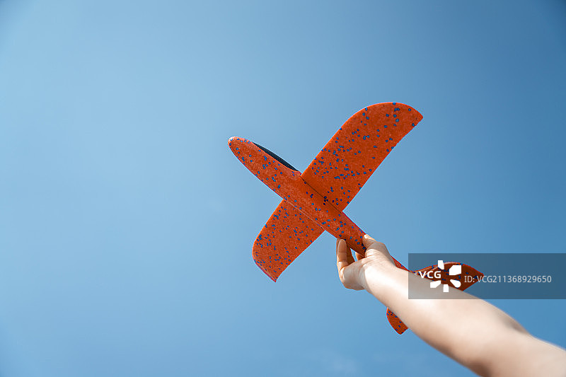 蓝天下手持飞机模型图片素材