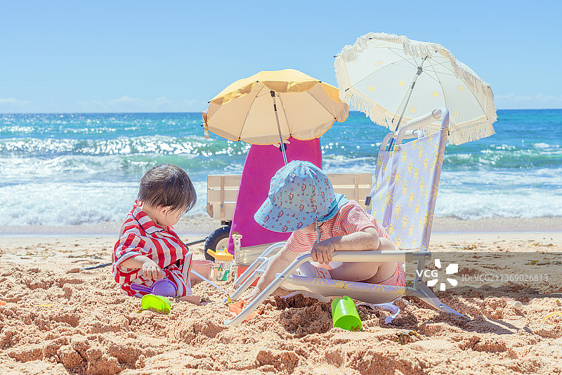 阿瓦隆海滩玩挖沙游戏的两个小孩图片素材