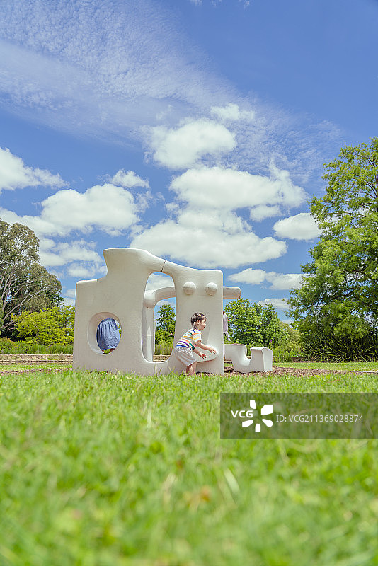 公园草坪白色雕塑处的小女孩图片素材