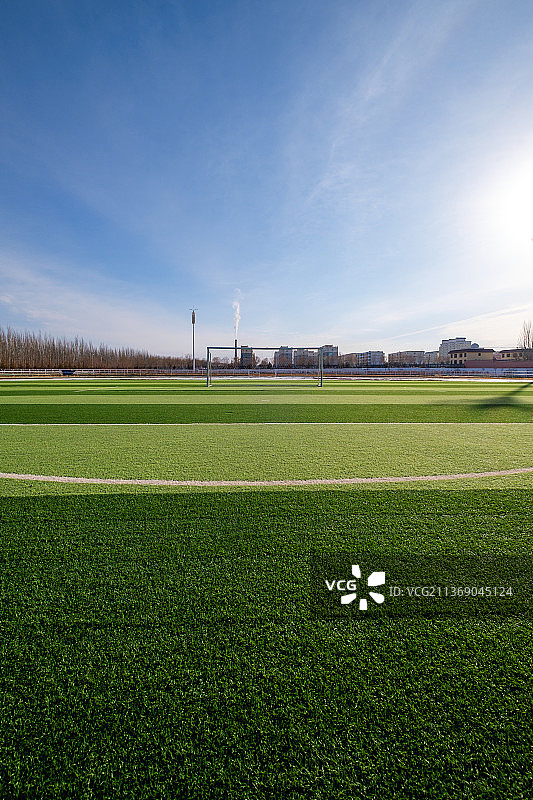 蓝天白云下的足球场垂直画面图片素材