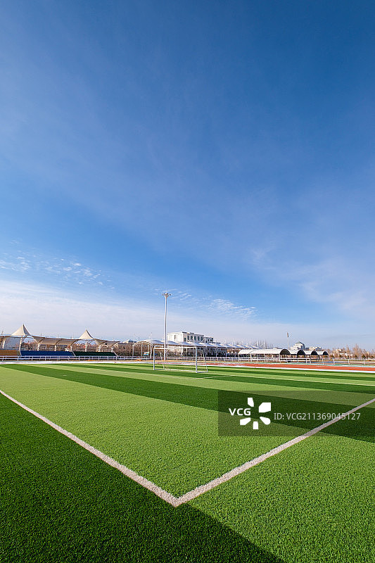 蓝天白云下的足球场垂直画面图片素材