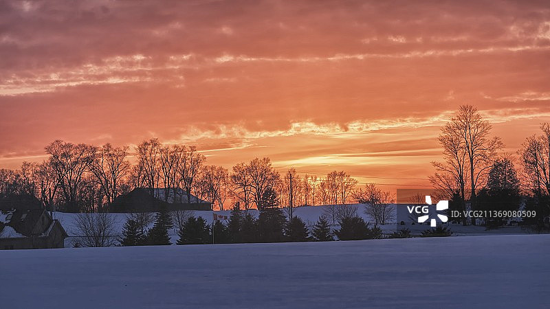 晚霞下雪坡后的人家图片素材