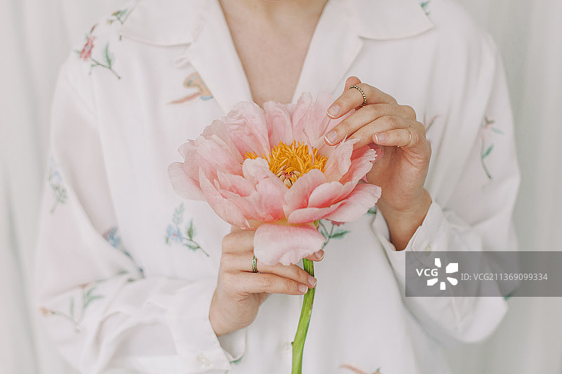 时尚女孩身穿白色碎花衬衫，温柔地捧着牡丹花图片素材