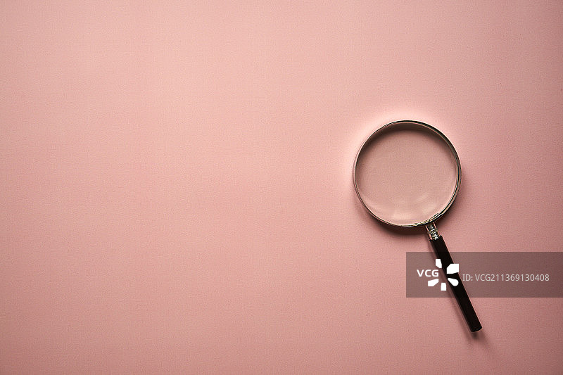 粉色背景上的放大镜，波兰图片素材