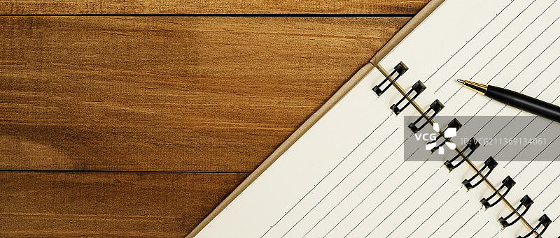 素描笔记本和钢笔，木桌上打开的书本图片素材