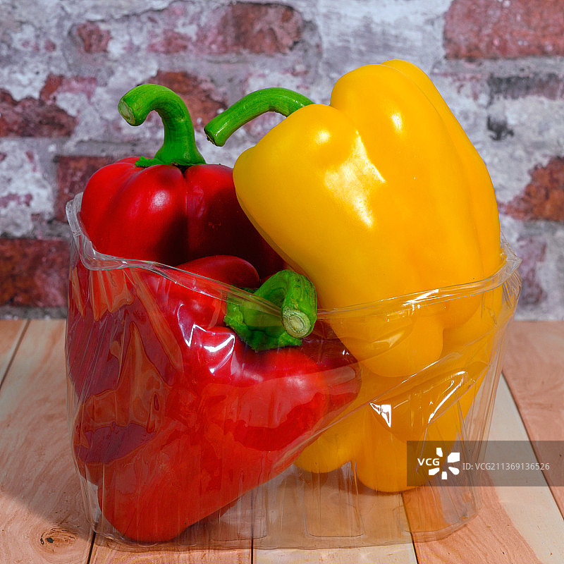 木桌上透明盒子里的甜椒图片素材