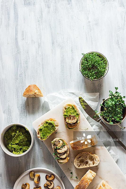 法棍面包配牛油果酱、口蘑和微型蔬菜图片素材