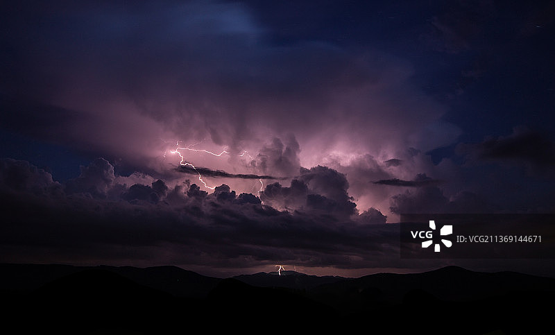 夜晚天空背景下的风景剪影和闪电图片素材