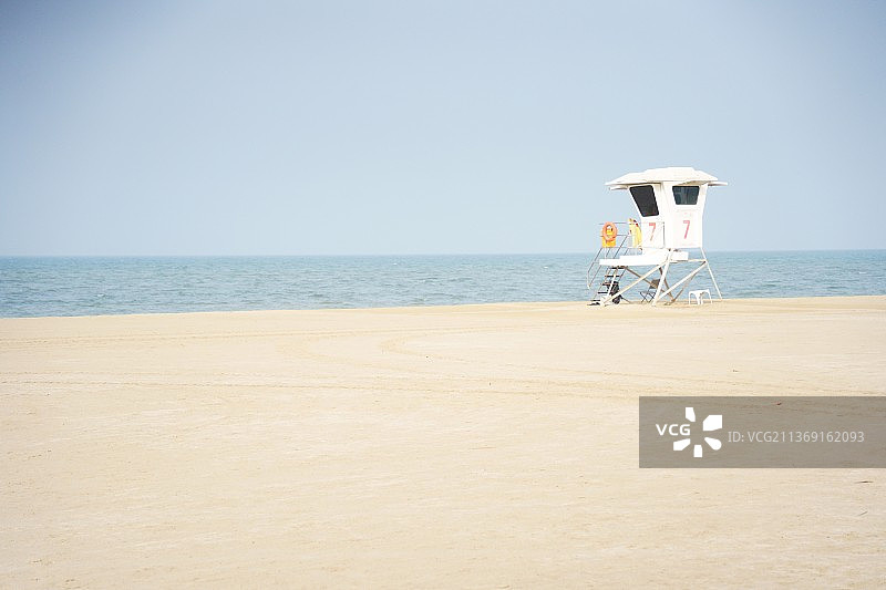 女子站在海滩，背景是天空图片素材