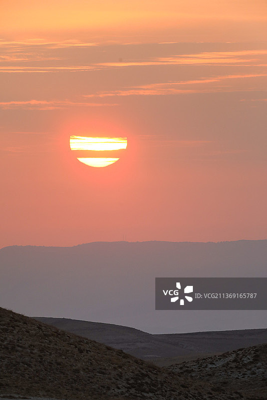 朱迪安沙漠河谷的日出美景，阳光冲破云层图片素材
